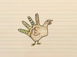 A child's drawing, outline of a hand with details drawn on it to resemble a turkey. 